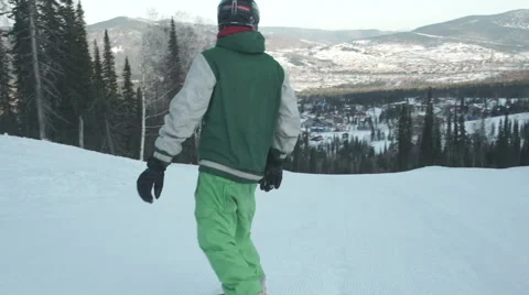 Snowboarder coming down on an empty snow-covered road Stock Footage 62539270