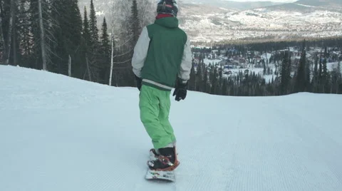 Snowboarder coming down on an empty snow-covered road Stock Footage 62539299