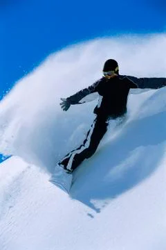 Snowboarder coming down snowy hill smiling Stock Photos