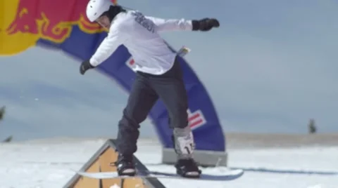 Snowboarder does backside switch to frontside grind on rail in terrain park Stock Footage 61626762
