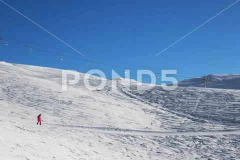 Snowboarder downhill on ski slope at cold sun morning Stock Photos