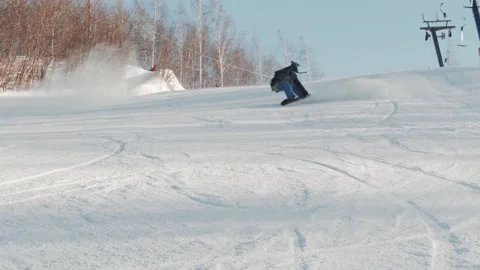 Snowboarder extremely carves and performs an indie grab butter trick Video stock 221581589