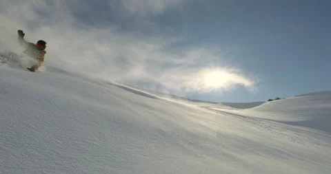 Snowboarder falls down the slope spraying clouds of snow. Freeride carving Stock Footage 256094490