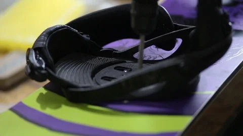 Snowboarder fastens the mount to the snowboard Stock Footage 105651444