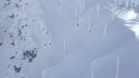 A snowboarder a fresh line down a mountain on a sunny day Stock Footage 150232997