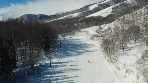 Snowboarder glides down an empty ski field Hakuba Japan. Stock Footage 165648120