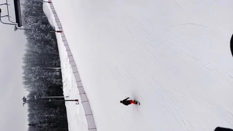 A snowboarder goes down a mountain, a guy goes snowboarding in a ski complex Stock Footage 238688392