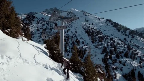 Snowboarder is jumping down from the cable car Stock Footage 72163861