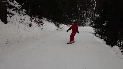 Snowboarder jumping lightly on snowy forest trail Stock Footage 327092629