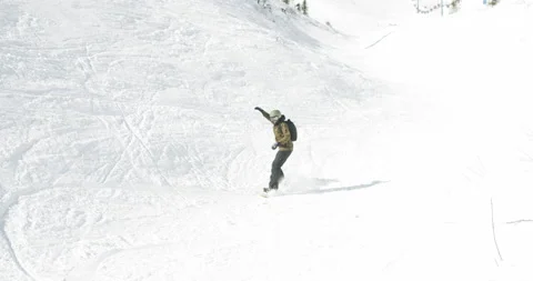 The snowboarder jumps down the slope. Stock Footage 144833854