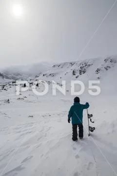 Snowboarder looking at the mountain getting ready for a free ride rush. Bad Stock Photos