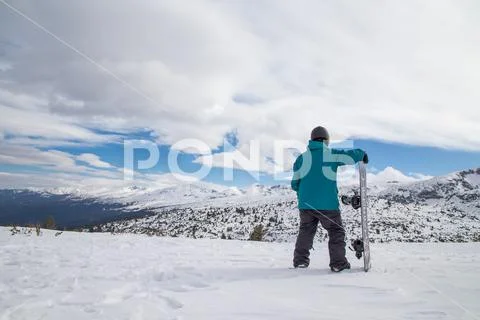 Snowboarder looking at the mountain getting ready for a free ride rush. Bad Stock Photos