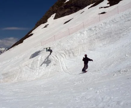 Snowboarder makes a jump while his friend takes pictures of him. Russia Sochi 스톡 사진