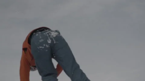 Snowboarder making speed and doing a front flip salto onto an air cushion Stock Footage 239711671