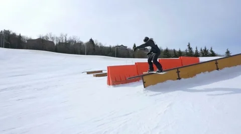 Snowboarder performs front side grind at terrain park Stock Footage 61626705