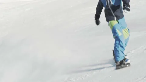 Snowboarder performs an ollie frontside 180 trick and falls on the slope Stock Footage 164043524