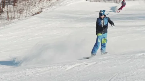 Snowboarder performs an ollie frontside 180 trick and goes down the slope Stock Footage 221581677