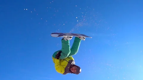 Snowboarder performs trick over the sunny blue sky. Stock Footage 60937903