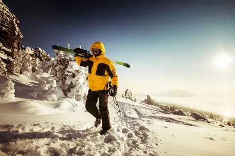 Snowboarder posing on blue sky backdrop in mountains Foto stock