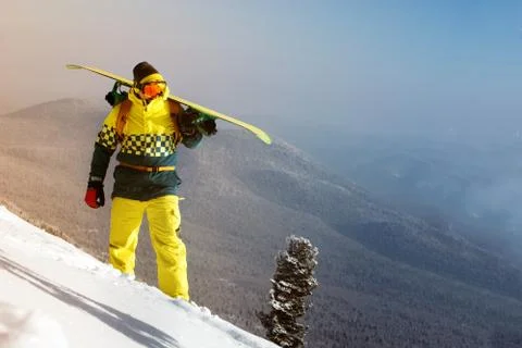 Snowboarder posing on blue sky backdrop in mountains Stock Photos