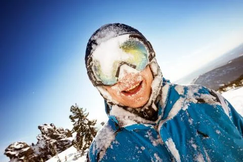 Snowboarder posing on blue sky backdrop in mountains Stock Photos