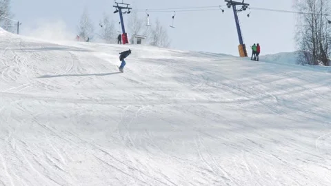 A snowboarder rides from a slope, makes several tricks and falls at high speed 스톡 동영상 221581786
