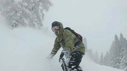 A snowboarder rides through deep snow and turns in the fresh powder. Stock Footage 107459431