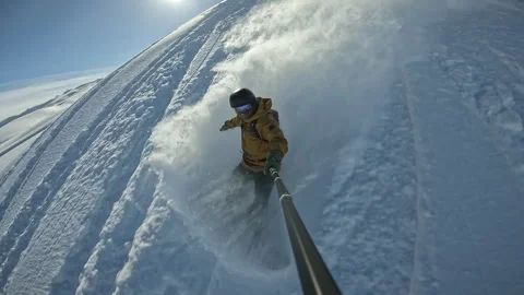 Snowboarder rides through deep snow and turns in the fresh powder. Snow splashes Video stock 246259673
