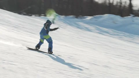 Snowboarder riding downhill and performs an ollie fs 180 trick 動画素材 221745484