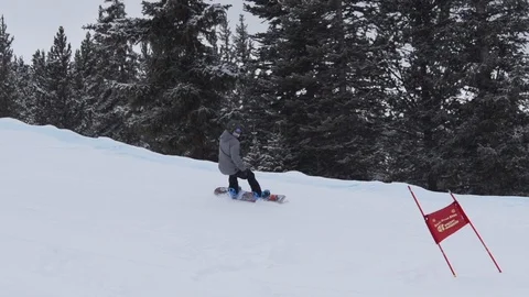 Snowboarder Riding Downhill Around Flags In Slow Motion 스톡 동영상 105932016