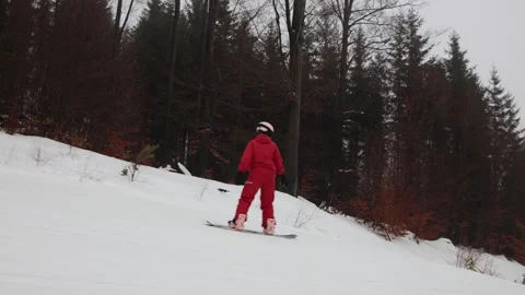 Snowboarder riding fast down snowy forest slope Stock Footage 327092628