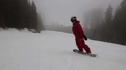 Snowboarder riding slowly through dense fog Stock Footage 327092545
