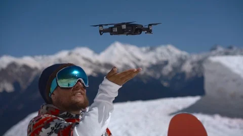Snowboarder running the drone in mountains Video stock 88548436