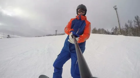 A snowboarder shows a beautiful sunset while descending a mountain. Front view f Stock Footage 130746705
