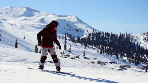 Snowboarder on slope go down fast pass with mountains background. Fun solo .. Stockbeeldmateriaal 252011869