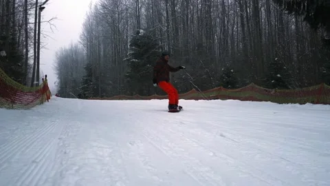 The snowboarder slows down sharply in front of the camera, slow motion, Stock Footage 230880512