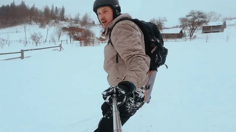 Snowboarder taking selfie while climbing mountain. snowboarder rides on the Stock Footage 72360506