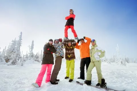 Snowboarders posing on blue sky backdrop in mountains Foto stock