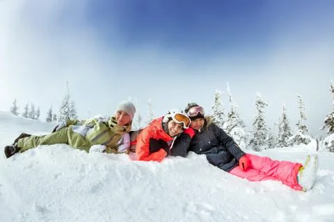 Snowboarders posing on blue sky backdrop in mountains Stock Photos