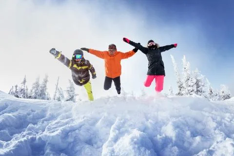 Snowboarders posing on blue sky backdrop in mountains Stock Photos