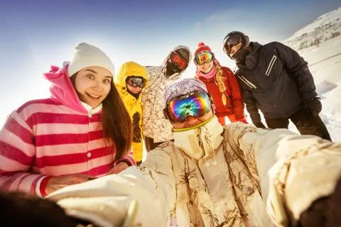 Snowboarders posing on blue sky backdrop in mountains Stock Photos