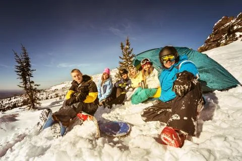 Snowboarders posing on blue sky backdrop in mountains Stock Photos