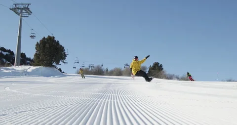 Snowboarders riding down ski resort slopes during winter vacation. Group of Stock Footage 254725997