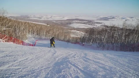 Snowboarders take turns rolling down the ski slope. Stock Footage 256156301