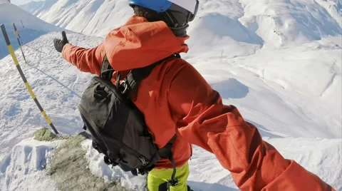 Snowboarding bgetting ready to dropp of a mountain top Stock Footage 67055907