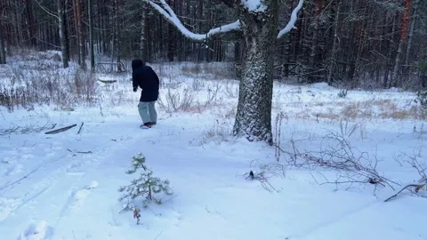 Snowboarding on flat surface in winter forest. Anonymous snowboarder riding a Stock Footage 257002290