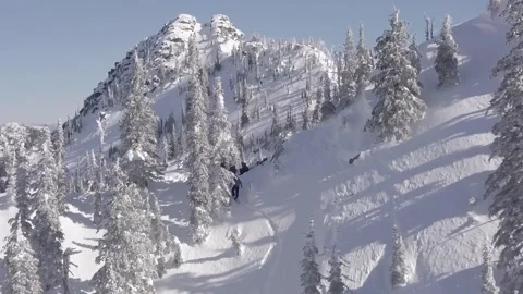 Snowboarding riding down a mountain in the sun Stock Footage 150135601