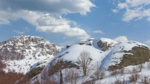 Snowbound mountain chain under a blue cloudy sky Stock Footage 252763571