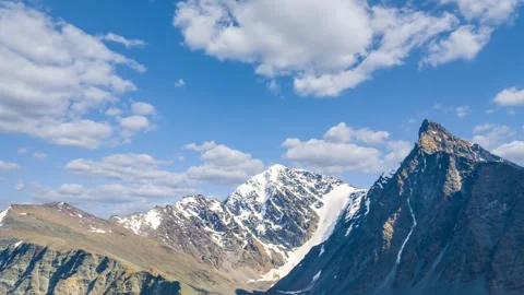 Snowbound mountain ridge under blue cloudy sky Stock Footage 327798871