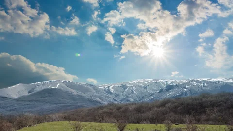 Snowbound mountain ridge under a sparkle sun time lapse scene Vídeos de archivo 253985510